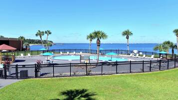 Relax by the pool surrounded by palm trees and ocean views.