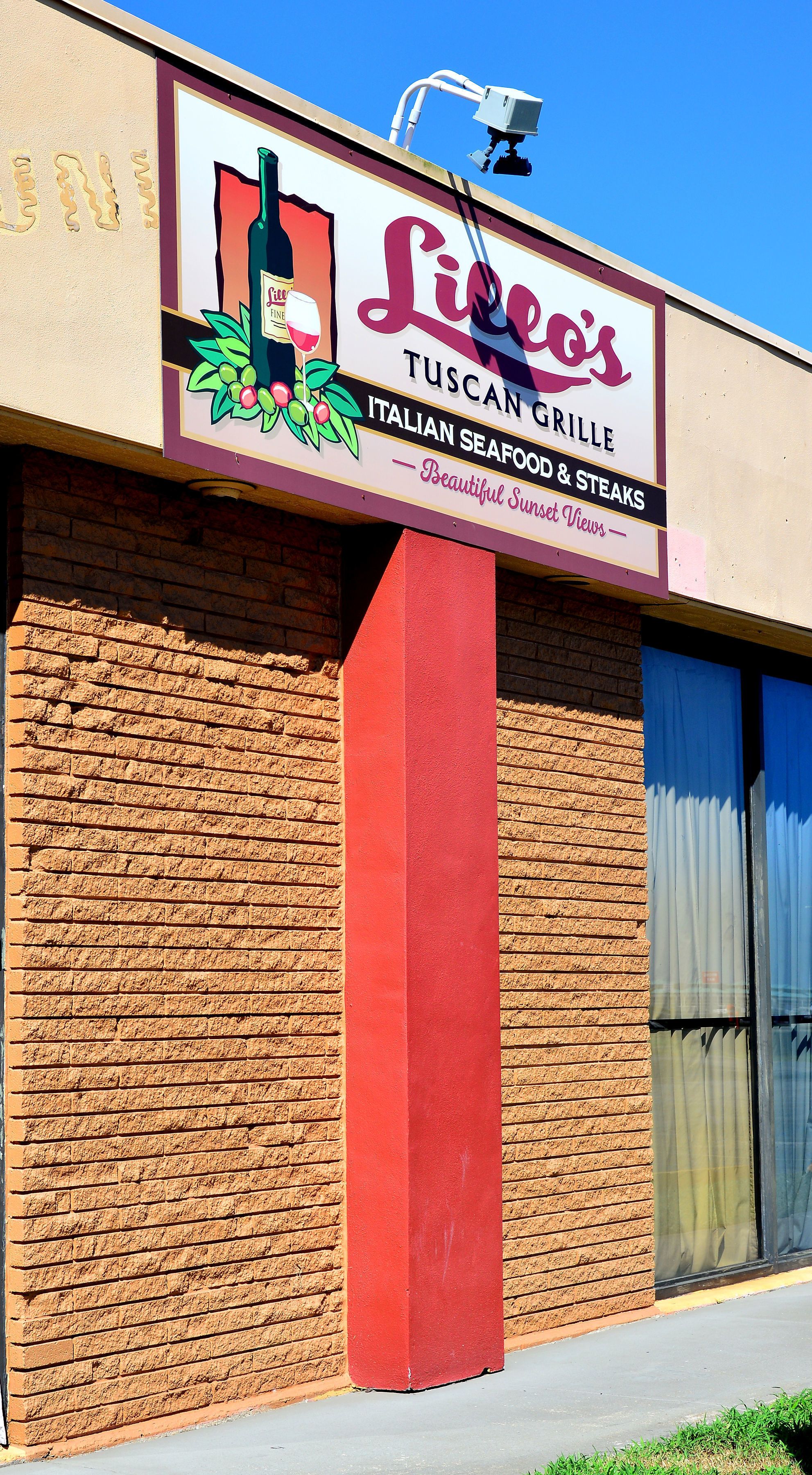 A building with a sign for "Liceo's Tuscan Grille" offering Italian seafood and steaks.
