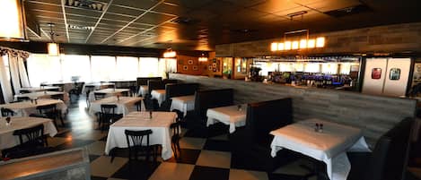 A restaurant with a checkered floor, booths, and a bar area.