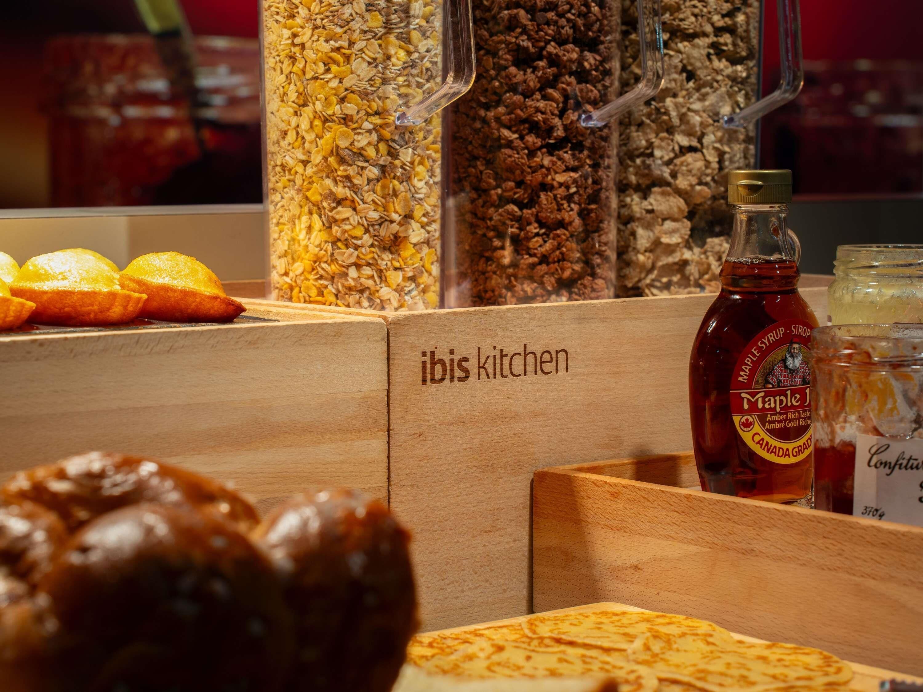Una barra de desayuno con granola y jarabe de arce, además de una botella de jarabe de arce.