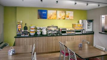 A breakfast bar with various food items and a coffee machine.