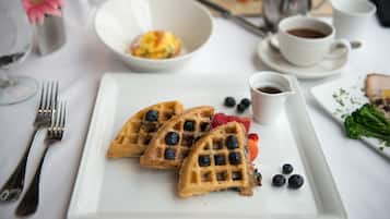 Een ontbijt met wafels, bosbessen en koffie.