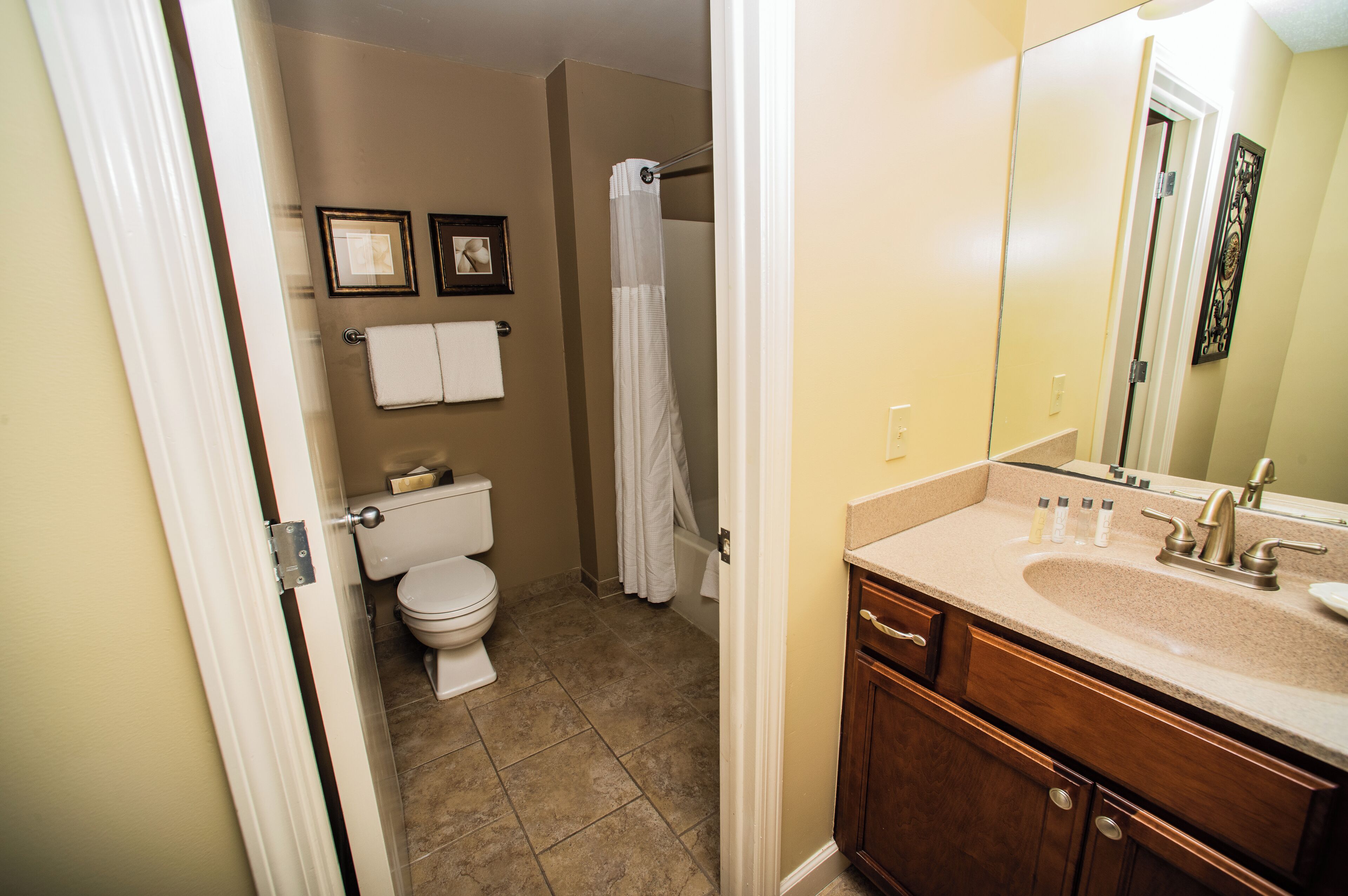 A bathroom with a toilet, shower, and sink.