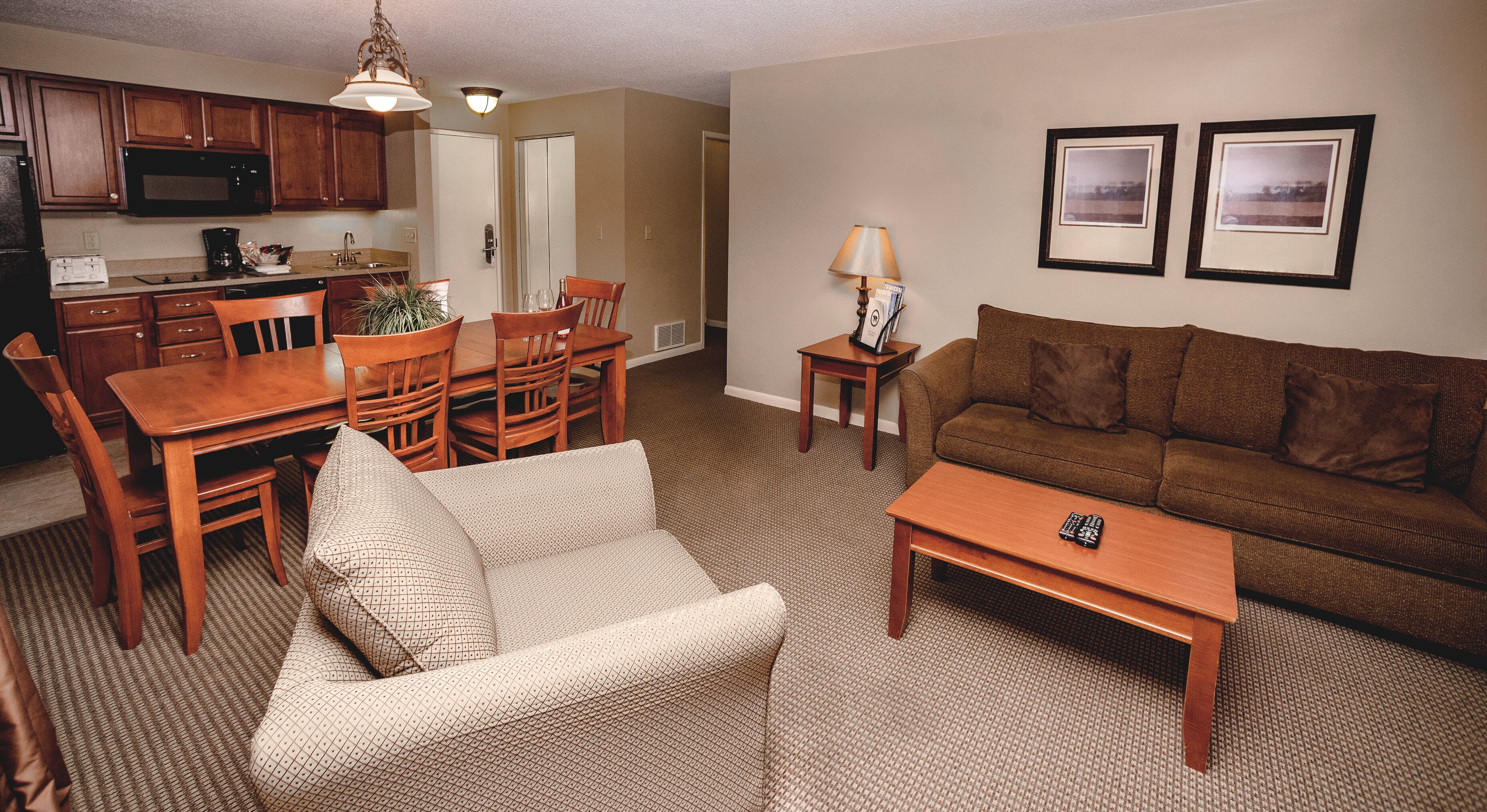 A compact living space with a dining area, a sofa, a coffee table, and a kitchenette.