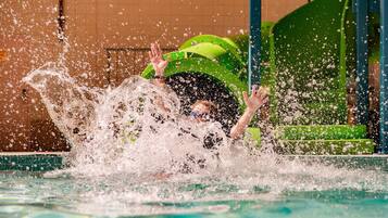 A person in a green helmet splashing in a pool.