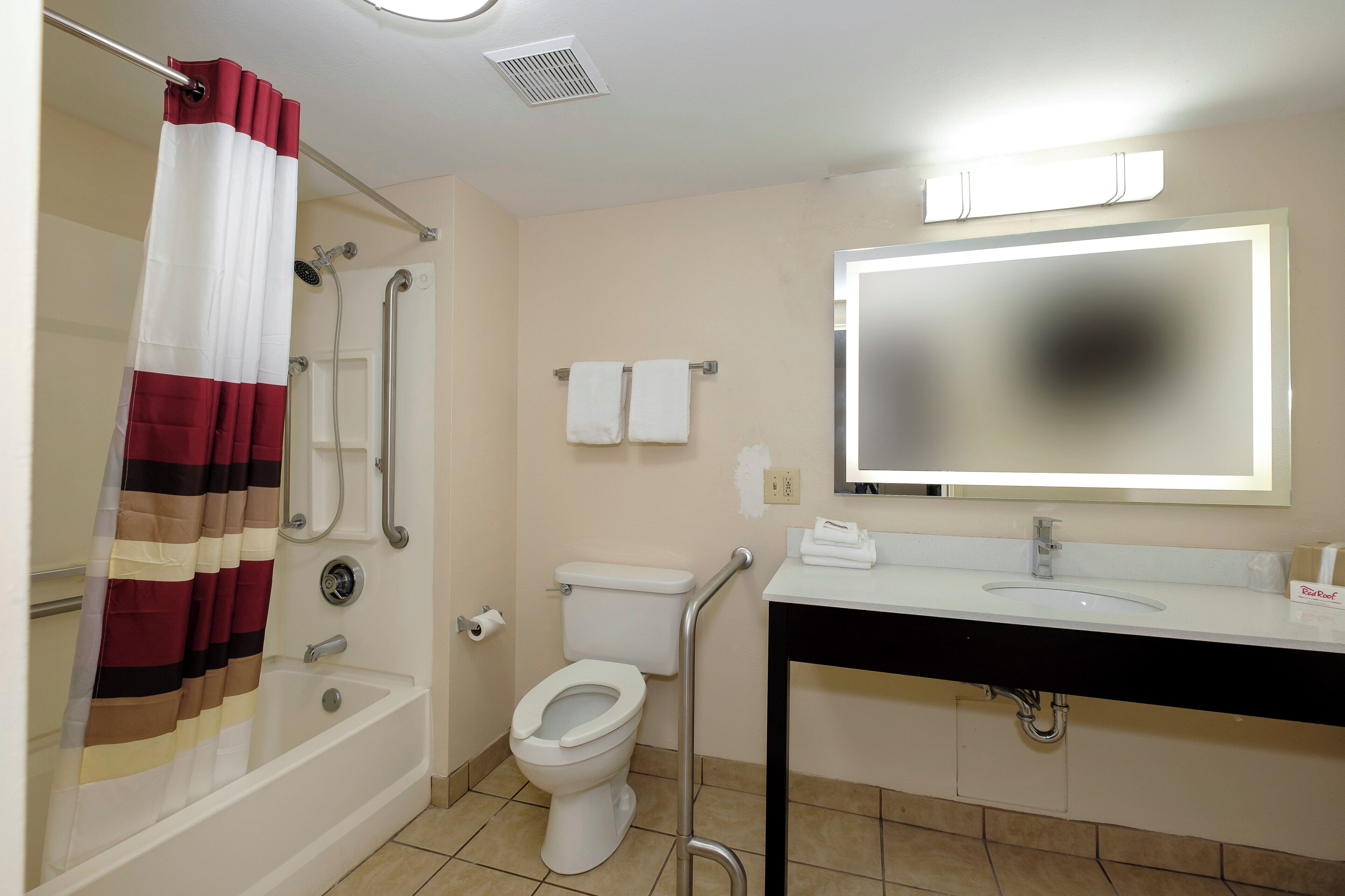 A bathroom with a shower, toilet, and sink.