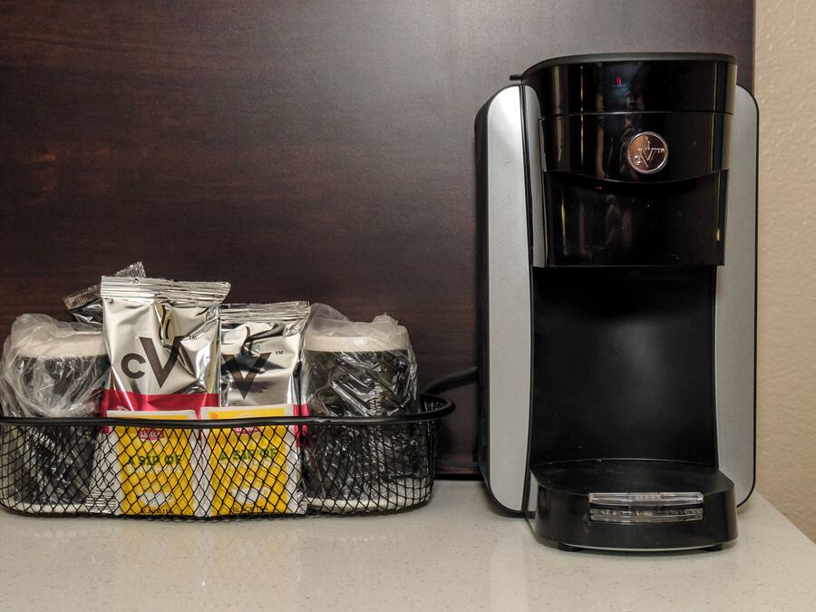 A coffee maker and a basket of coffee pods.