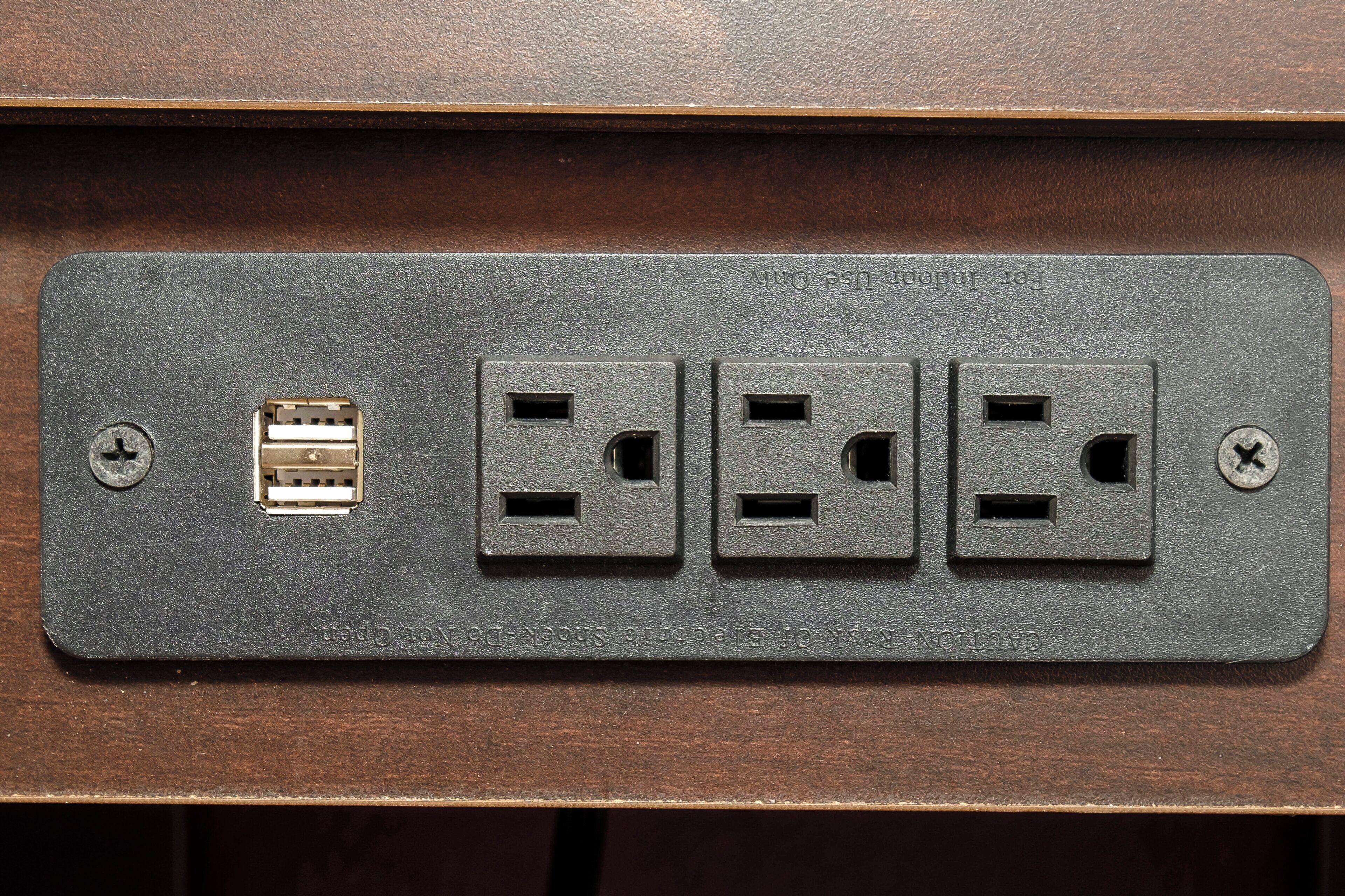 Une multiprise dotée de quatre prises, d’un port USB et de deux interrupteurs.