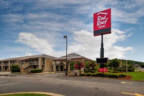 Un hôtel Red Roof Inn doté d’un parking et d’un bâtiment avec une entrée abritée.