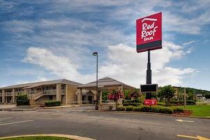 Un hotel Red Roof Inn con estacionamiento y un edificio con acceso cubierto.