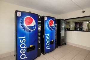 Dos máquinas expendedoras de Pepsi en una habitación con suelo de baldosas y una pared lisa.