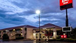 A Red Roof Inn with a clear sky, a well-lit entrance, and a sign indicating a 12 ft clearance. - Red Roof Inn Gadsden (Gadsden)