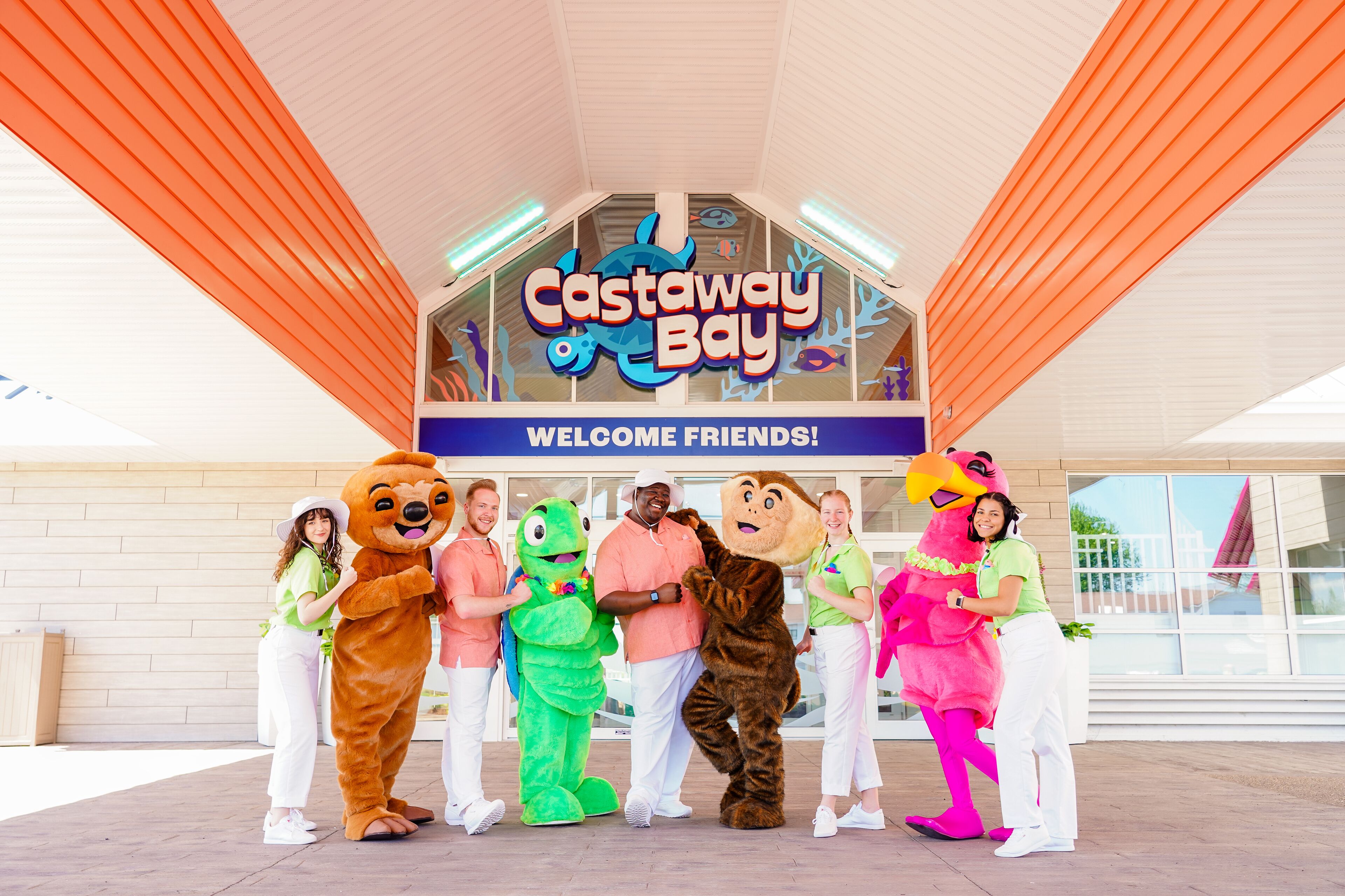 A group of people in various costumes standing in front of a sign that reads "Castaway Bay."