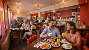 A breakfast setting with tables, chairs, and people dining.