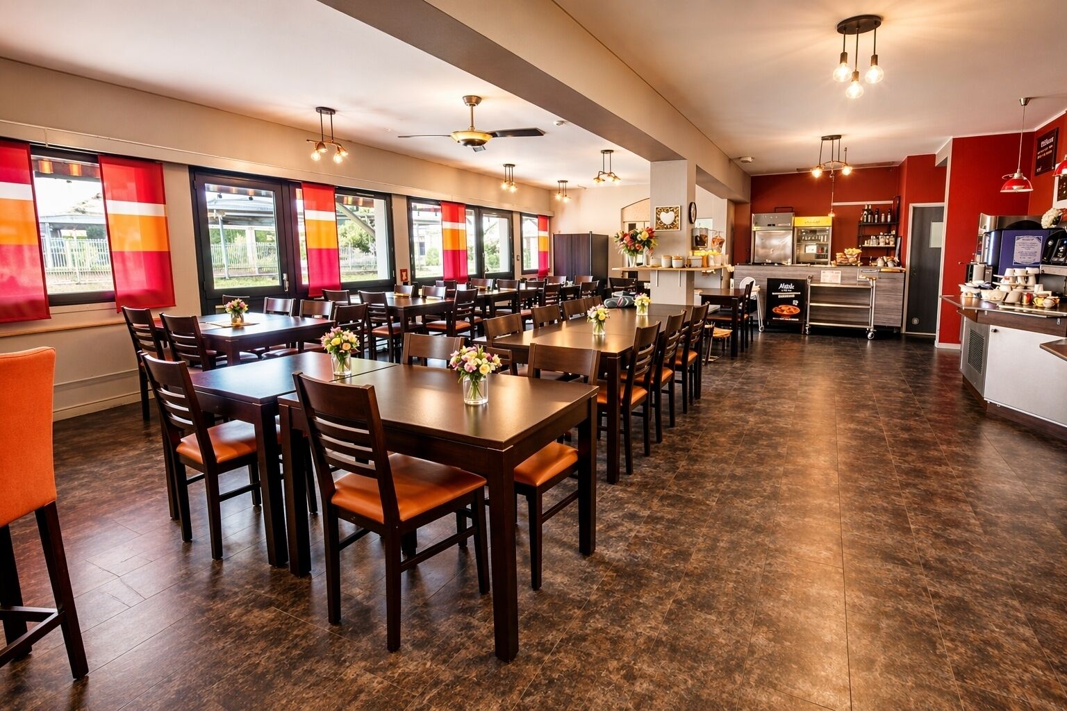 Een restaurant met meerdere eettafels en stoelen, een keuken en grote ramen met rode gordijnen.