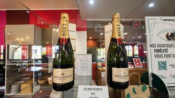 Two bottles of Moët & Chandon champagne on display with a sign indicating a points system for purchasing.