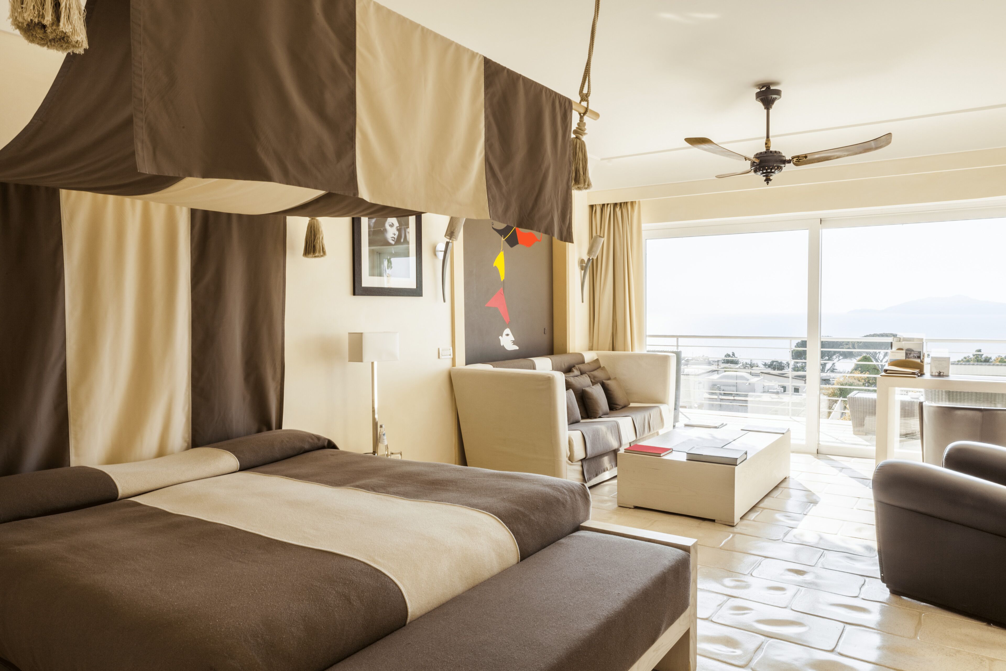 Une chambre d’hôtel avec un grand lit, un canapé, une table basse et un balcon avec vue.