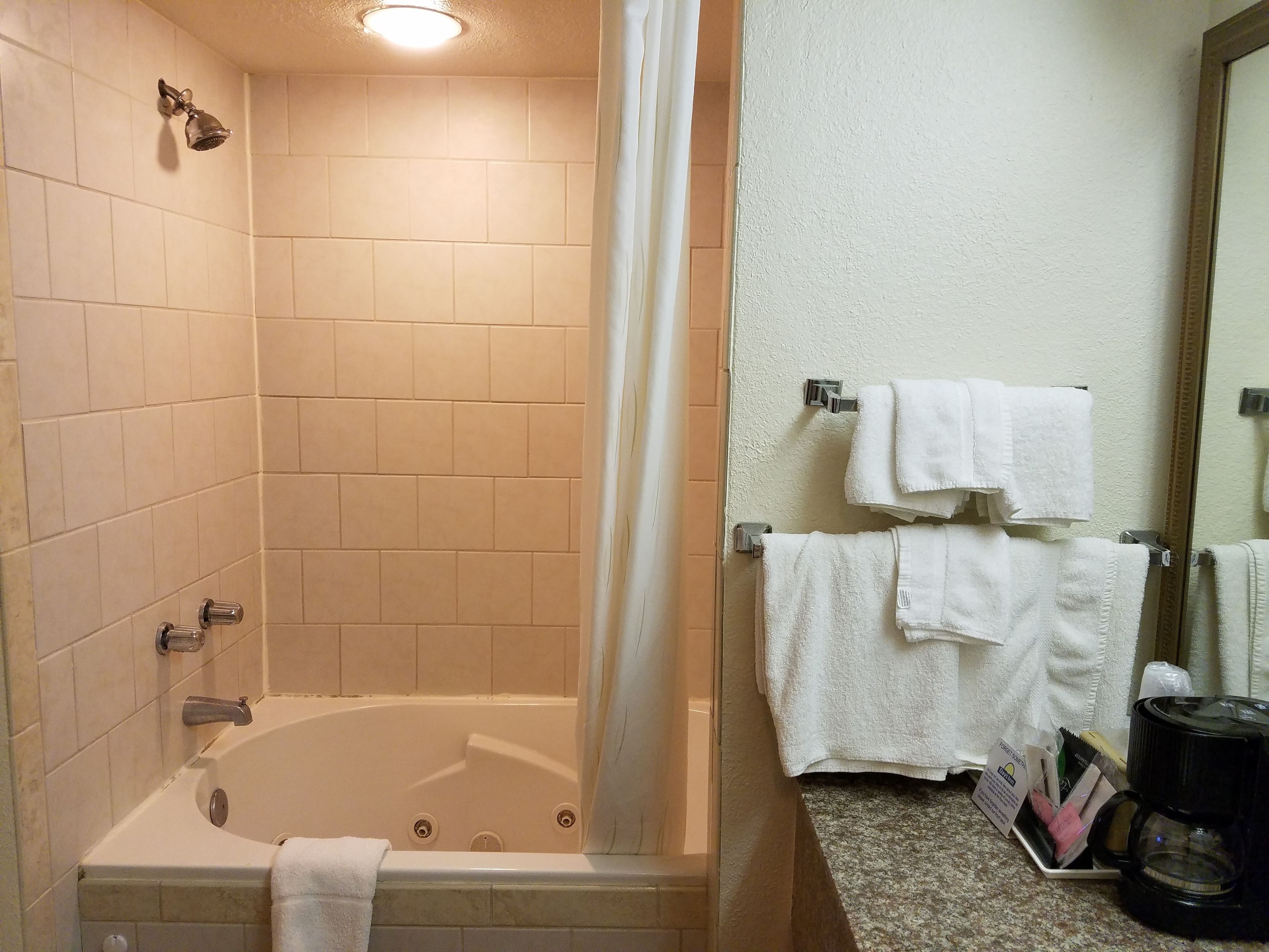 Un baño con bañera, cortina de ducha y toallero con toallas.