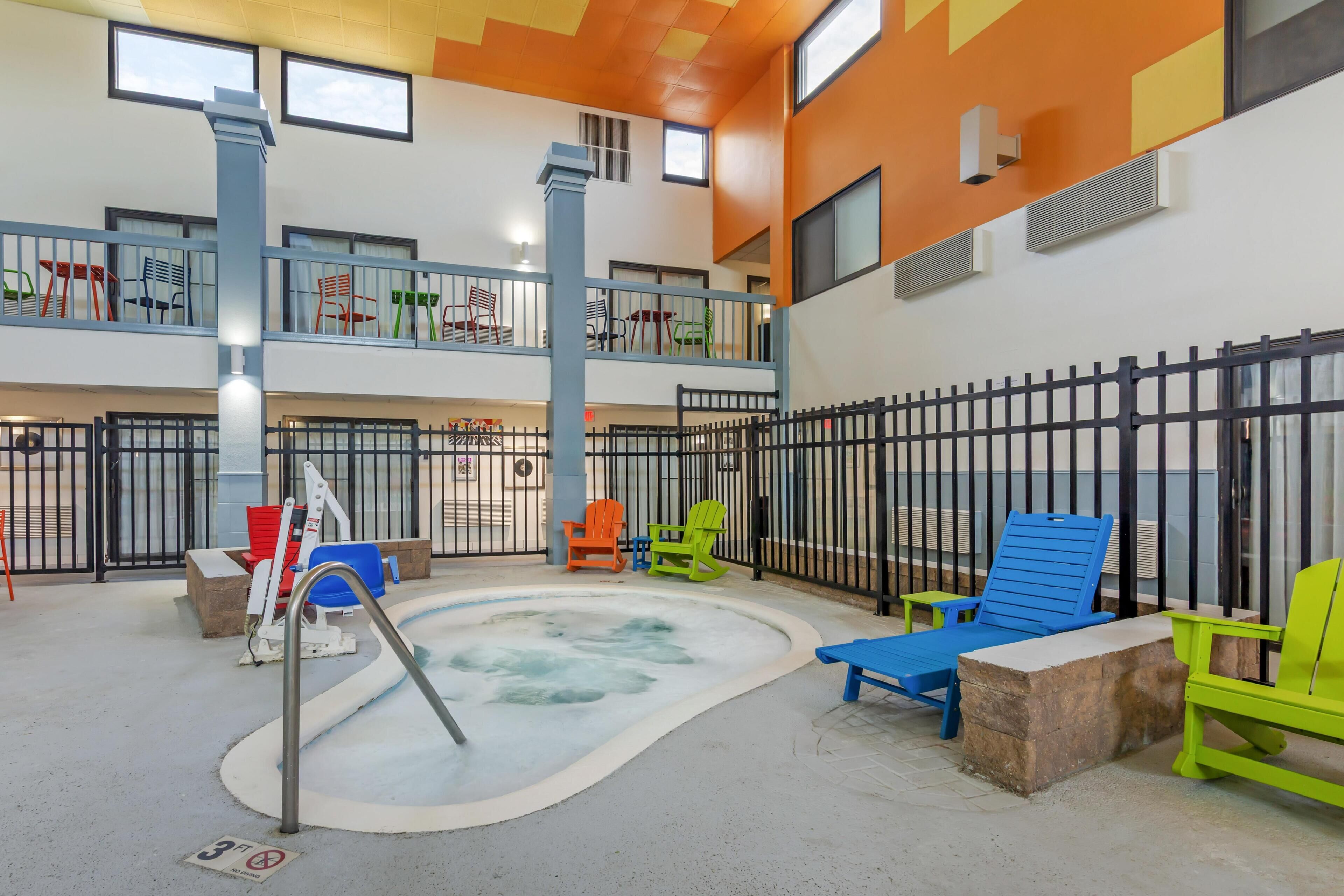 Espaço interior em vários n íveis, com área de piscina, assentos e varanda cercada.