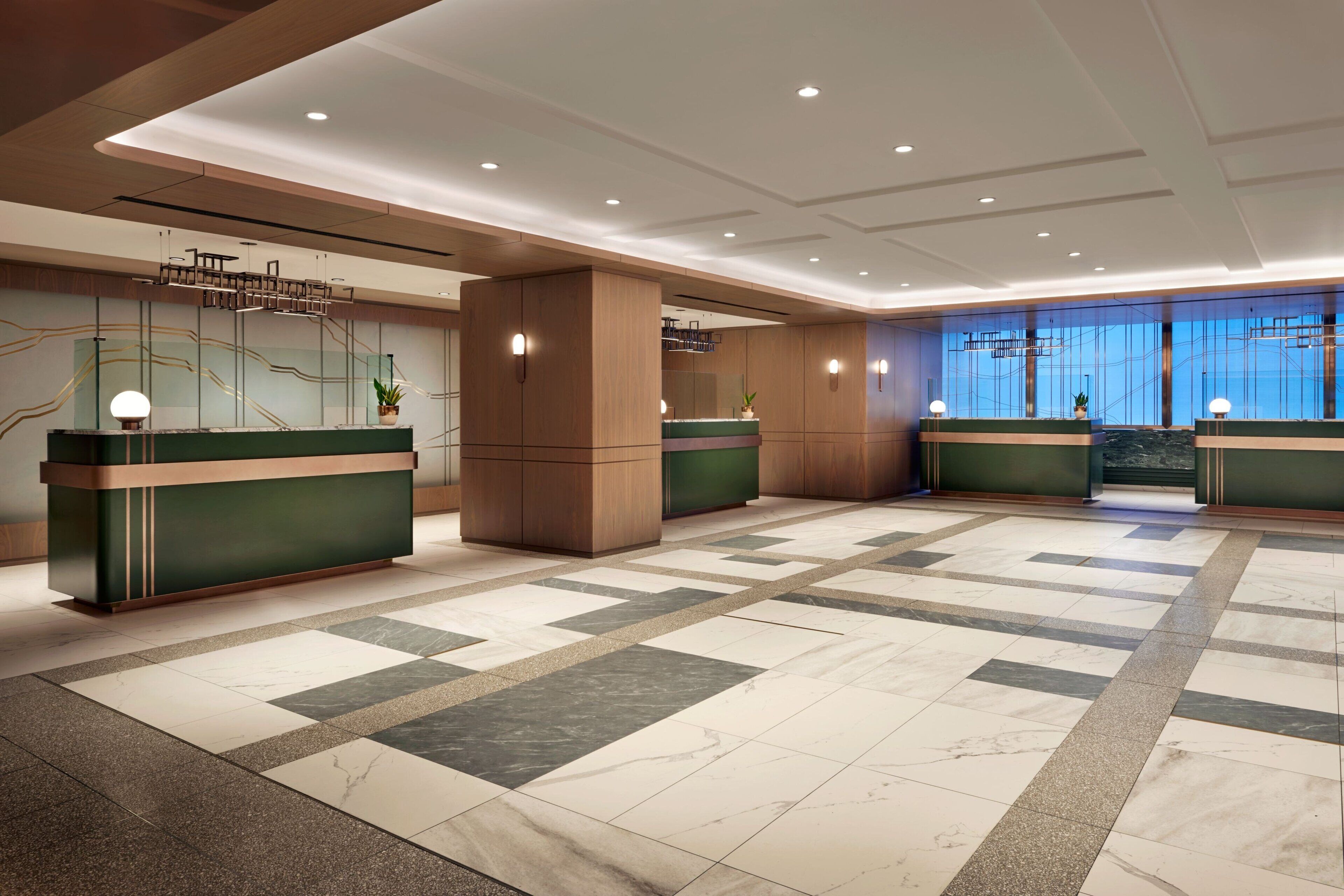 En rummelig lobby med skakternet gulv, reception og moderne lysarmaturer.