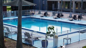 Una piscina al aire libre, sombrillas, sillones reclinables de piscina