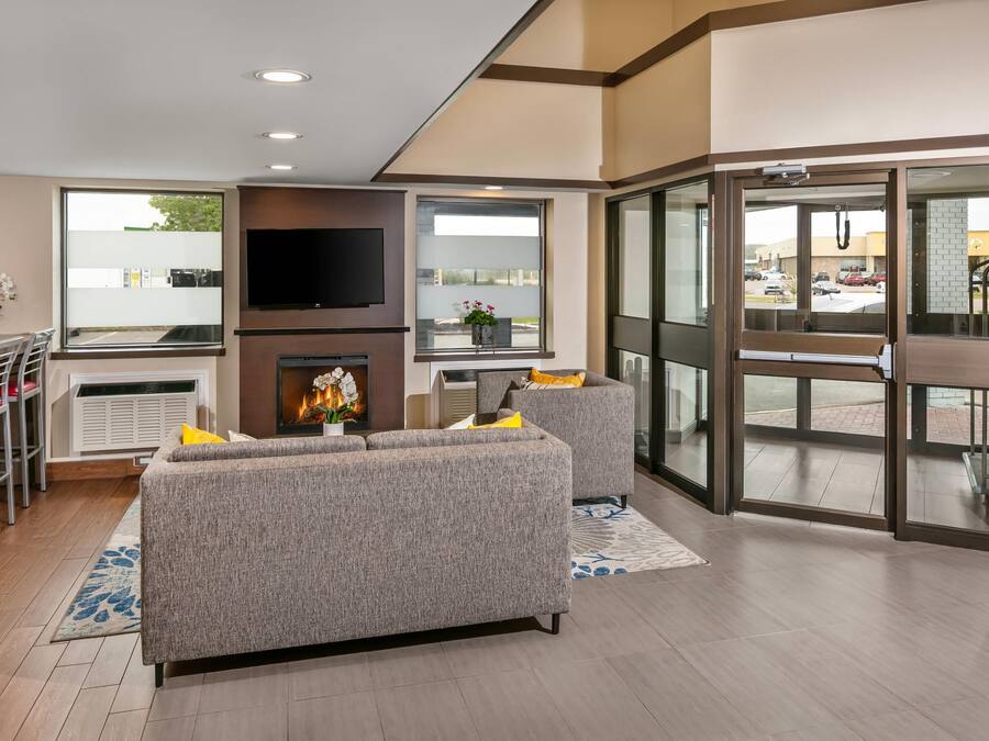 A modern living room with a fireplace, a flat-screen TV, and a seating area.