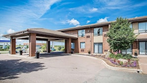 A two-story hotel with a covered parking area and a landscaped garden. - Comfort Inn Truro (Lower Truro)