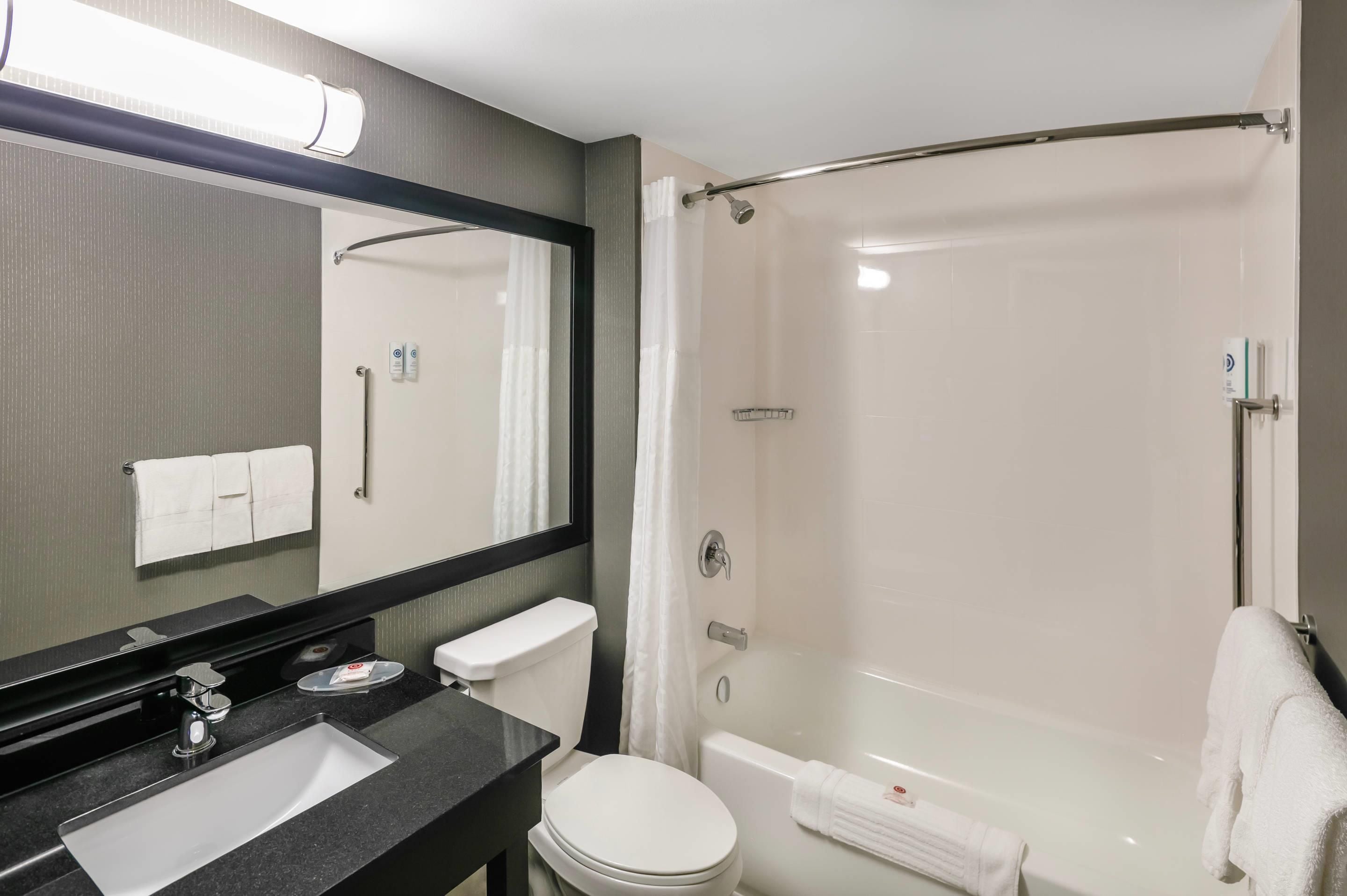 Et moderne badeværelse med vask, toilet og brusekabine.