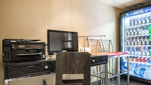 A small office area with a printer, monitor, and chair. There is a vending machine with various beverages and a sign that says "Business Supplies Available." - Comfort Inn Truro (Lower Truro)