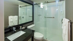 A modern bathroom with a glass-enclosed shower, a black sink, and a white toilet. - Comfort Inn Truro (Lower Truro)