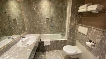 Une salle de bain avec deux lavabos, une baignoire et des toilettes.