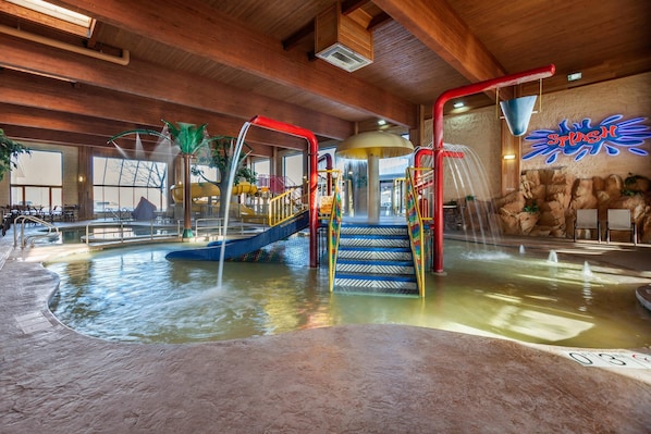 Parque acuático interior con toboganes, zona de escalada y piscina.