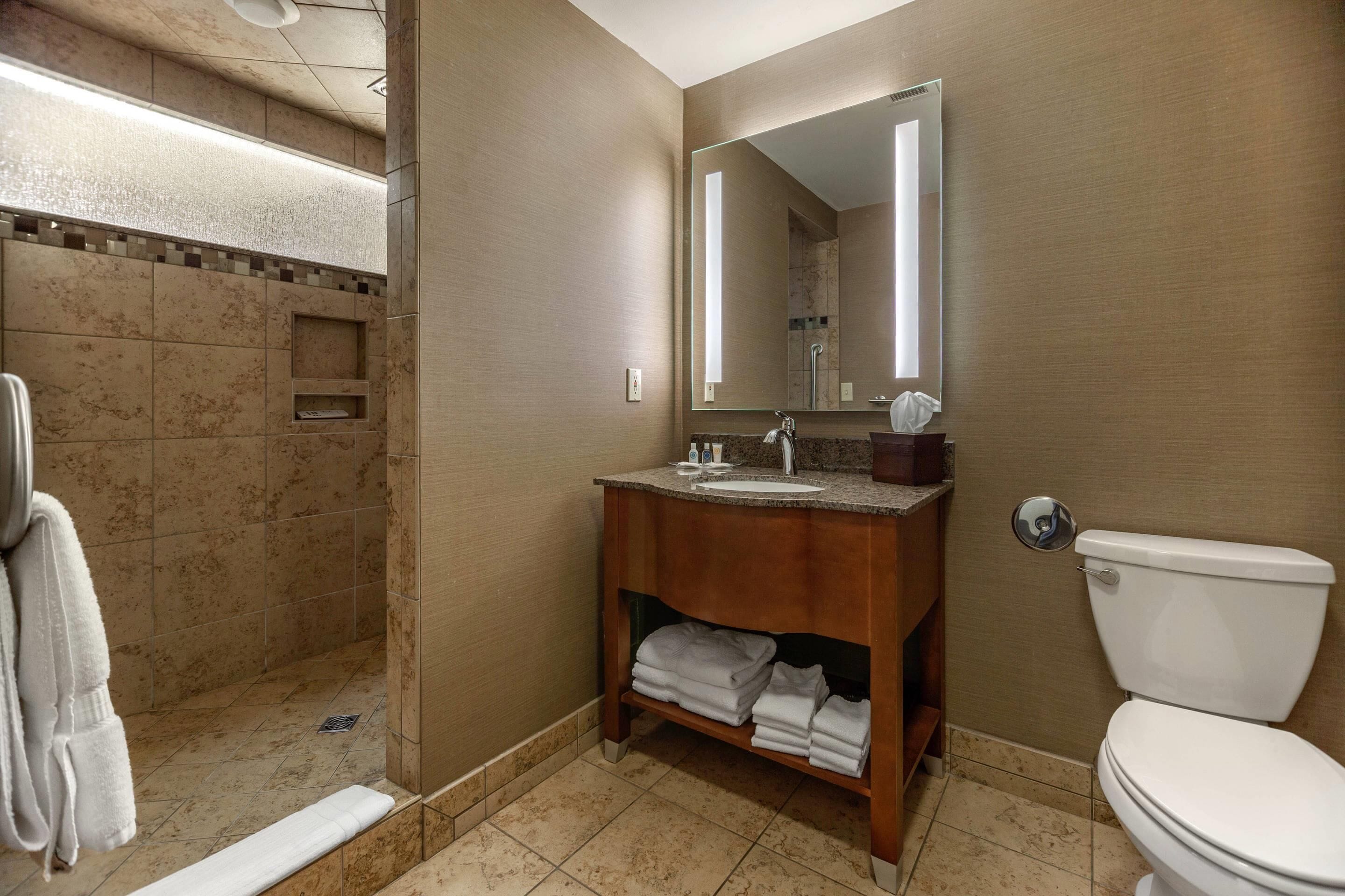 A bathroom with a shower, sink, and toilet.