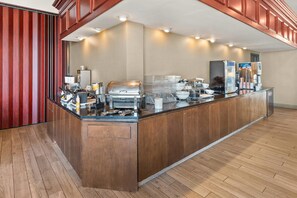 A self-service breakfast bar with a variety of food and beverage dispensers, a refrigerator, and a coffee machine. - Comfort Suites Green Bay West (Green Bay)