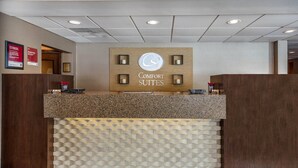 En reception med et skilt der siger 'COMFORT SUITES' og en logo over det.