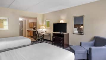 A hotel room with two beds, a desk, a chair, a TV, and a mirror.