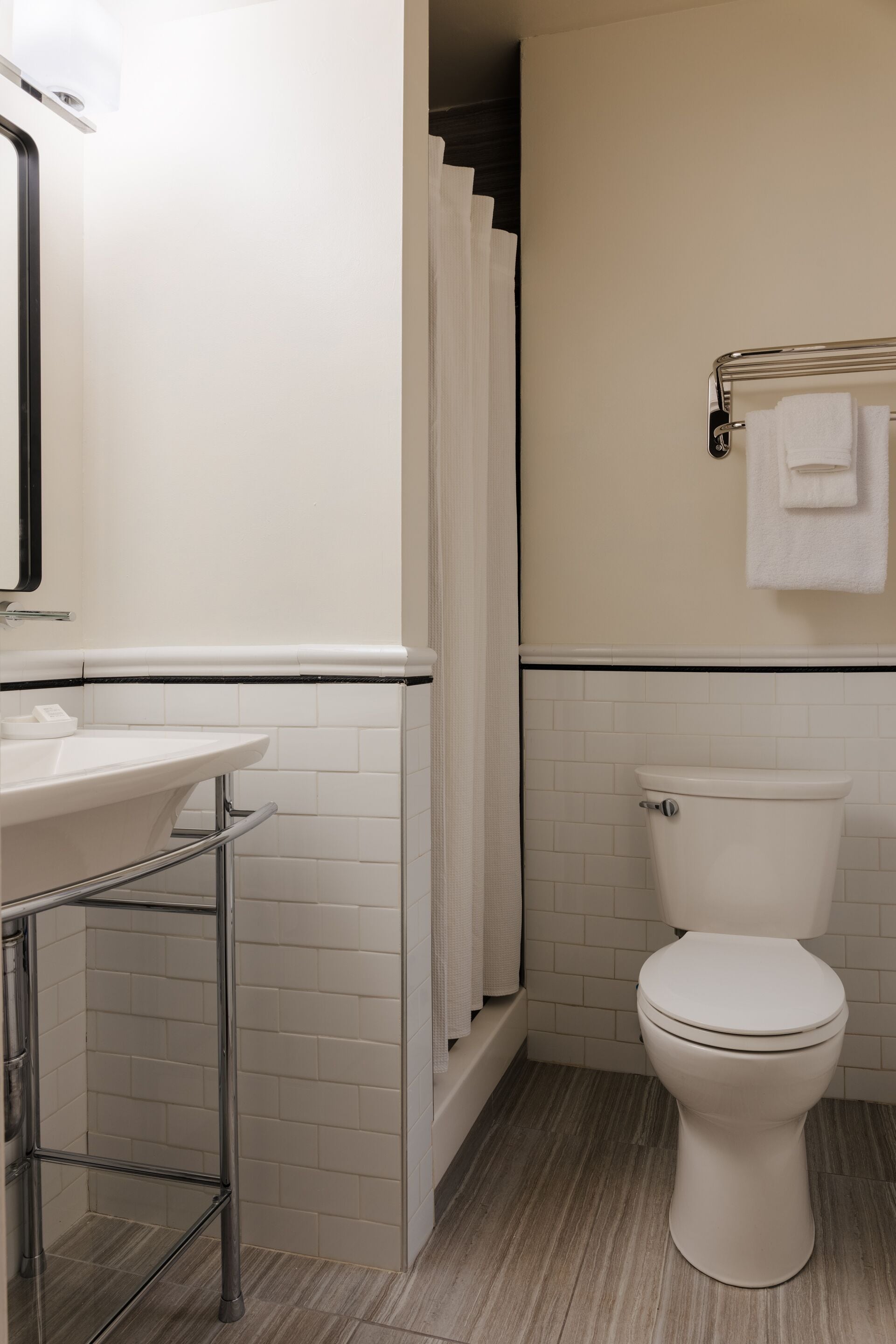 A bathroom with a white sink, a toilet, and a shower curtain.