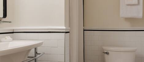 A bathroom with a white sink, a toilet, and a shower curtain.