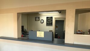 Mostrador de recepción de hotel con un cartel que indica que se aceptan descuentos al registrarse.