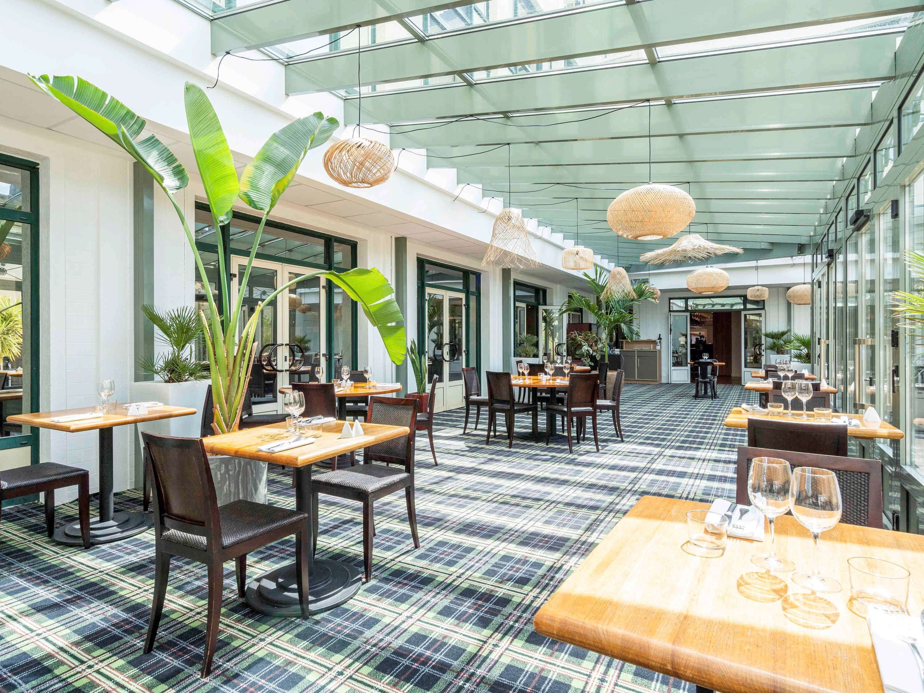 Een restaurant met een geruit vloerkleed, houten tafels en stoelen.