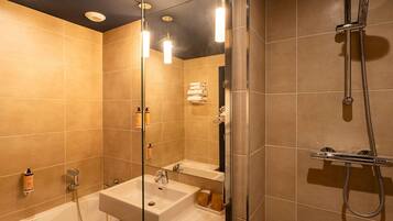 A modern bathroom with a glass shower enclosure, a sink, and a mirror.