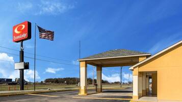 A parking lot with a covered area, a sign for EconoLodge, and an American flag.