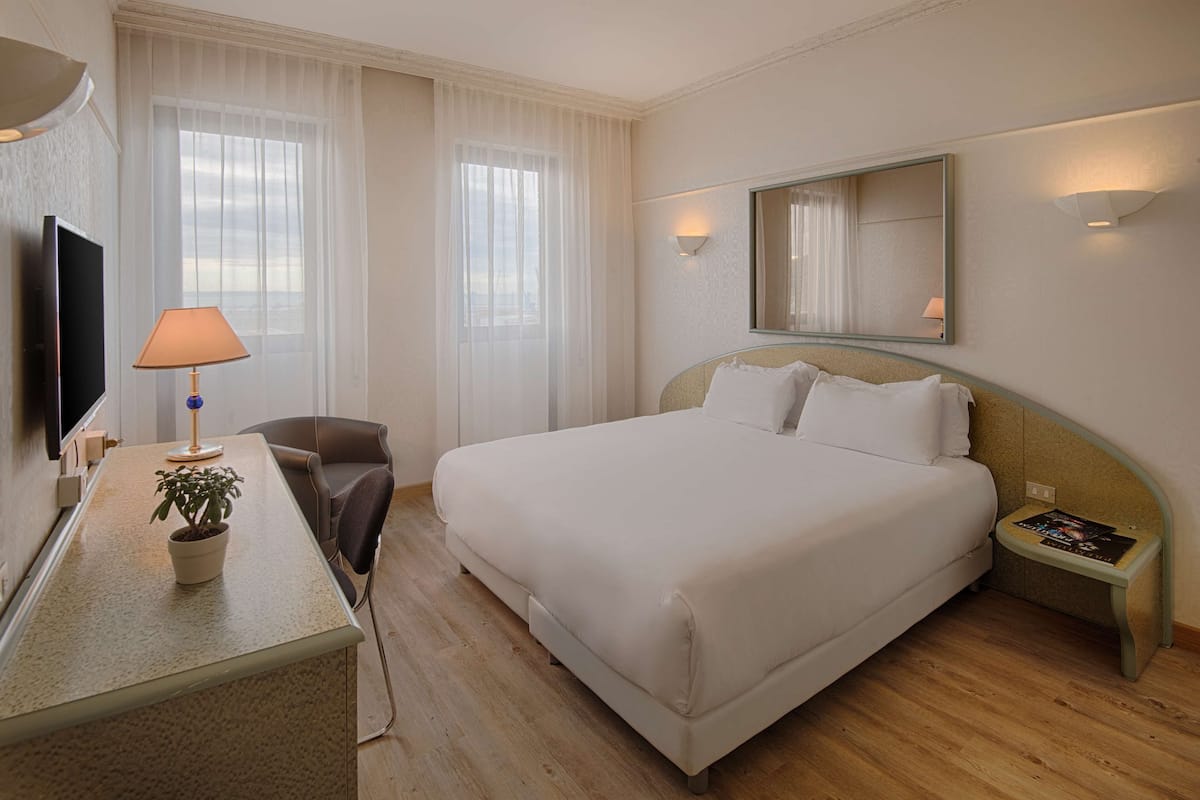 Habitación estándar | Edredón, minibar, caja de seguridad en la habitación y escritorio