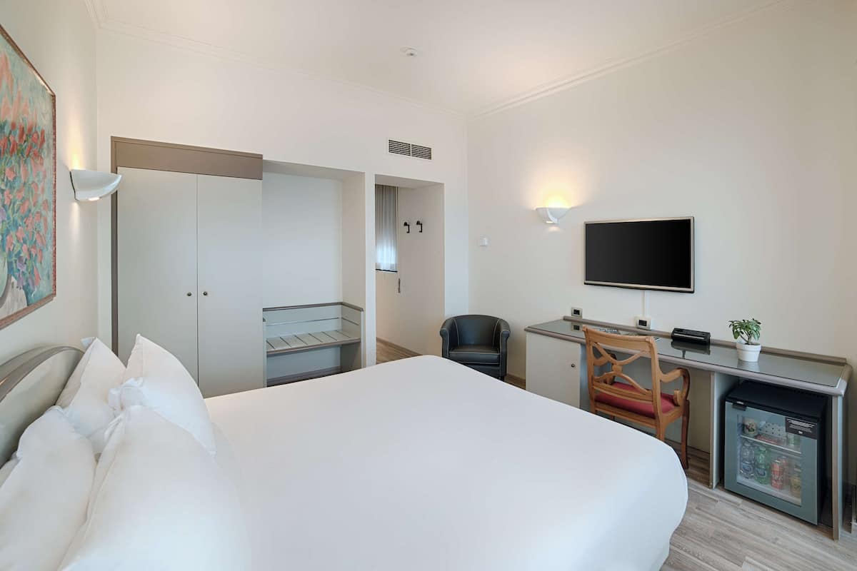 Habitación superior | Edredón, minibar, caja de seguridad en la habitación y escritorio