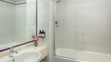 Ein Badezimmer mit Waschbecken, Spiegel und Dusche.