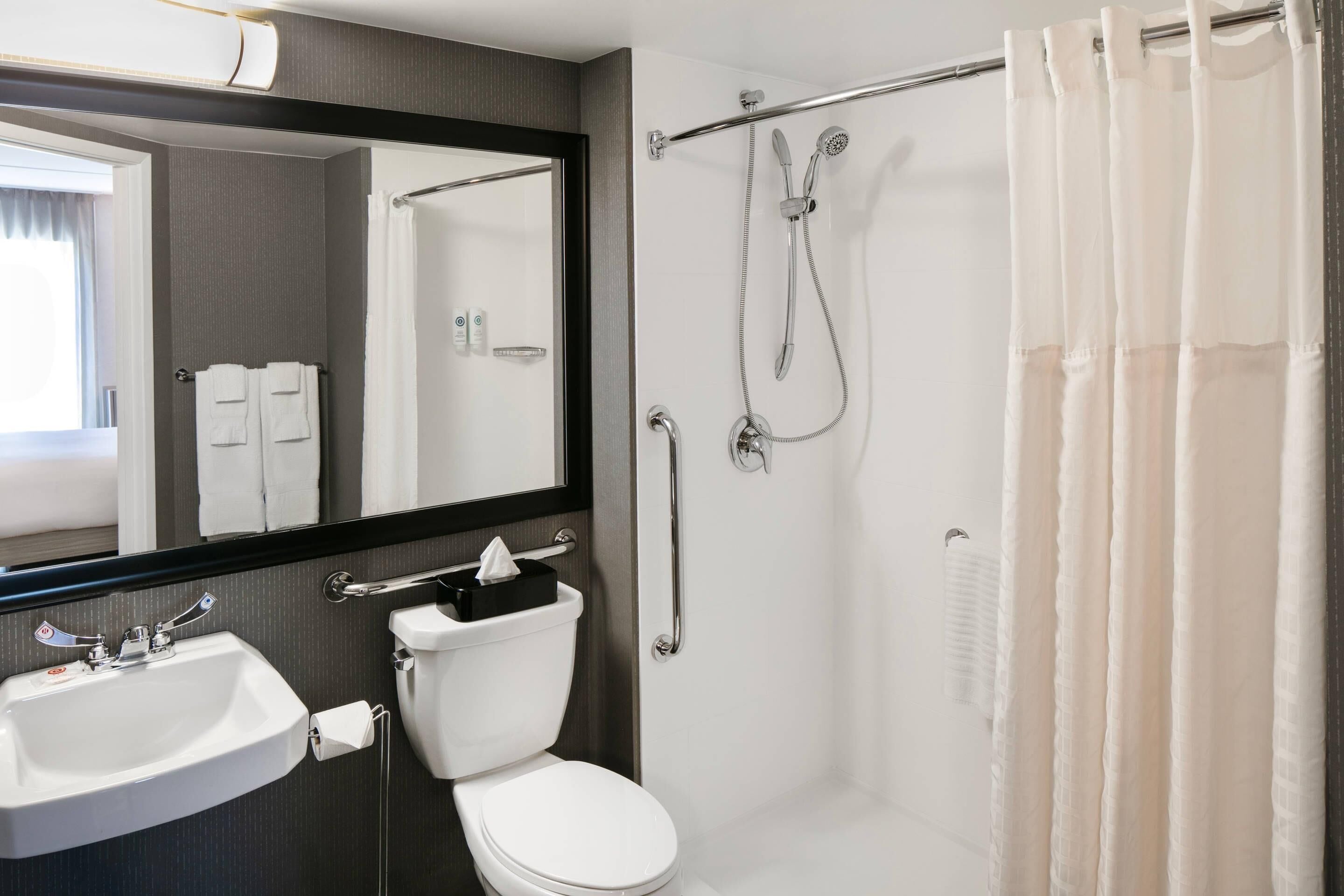 A modern bathroom with a toilet, sink, and shower.
