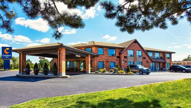A Comfort Inn hotel with a covered outdoor area, brick building, and a parking lot. - Comfort Inn (Yarmouth)