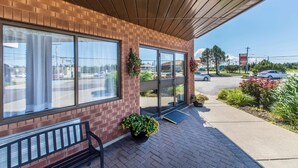 A brick building with large windows, a covered patio, and potted plants. - Comfort Inn (Yarmouth)
