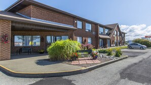 A two-story building with a brick facade, large windows, and a parking lot. - Comfort Inn (Yarmouth)