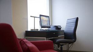 A workspace with a desk, computer, chair, and a red sofa. - Comfort Inn (Yarmouth)